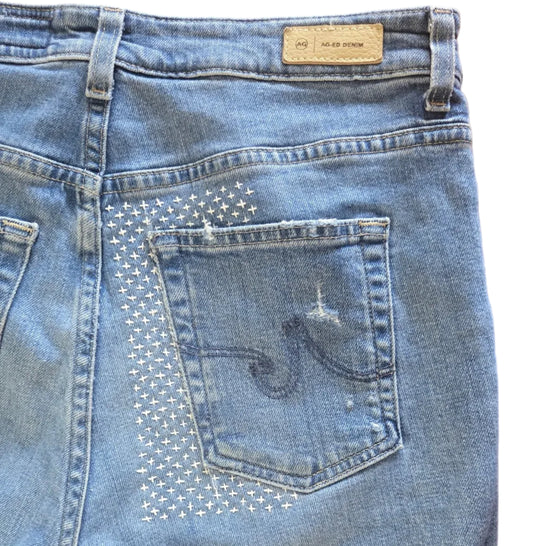 Blue denim jeans with Sashiko mending around the back pocket 