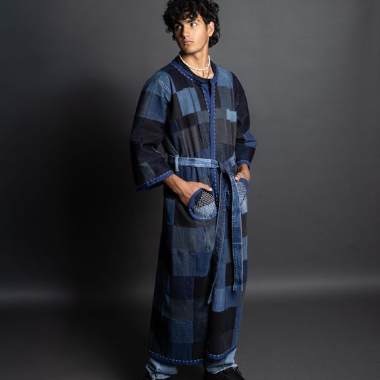 Person wearing a long, patterned blue robe against a gray background